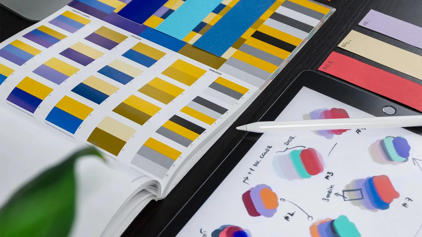 A design studio desk covered in swatches, markers and printed layouts